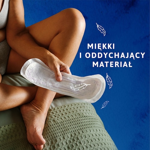 Osoba trzymająca wkładkę TENA, siedząca na łóżku, z napisem "Miękki i oddychający materiał".