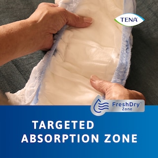 Gros plan du produit TENA Pants protect+ tenus dans les mains, démontrant sa zone d’absorption ciblée
