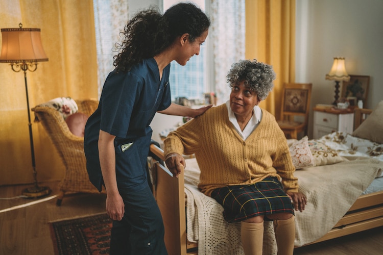 A male professional caregiver talks with a female TENA representative in an office in a nursing home