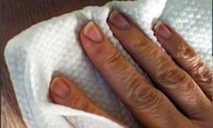 Roka, kas izmanto TENA tīrīšanas salveti