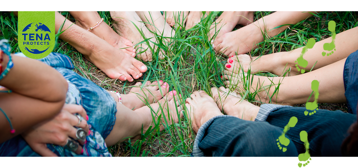 Bare feet of group of young girls in a circle on green grass 