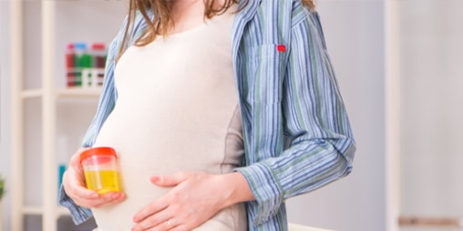Mulher grávida com um frasco de urina