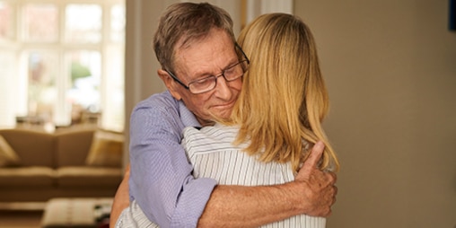 Un anziano abbraccia la sua caregiver