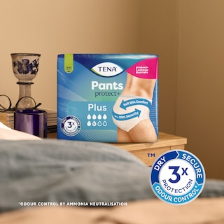 Pack of TENA Pants protect+ on a bed table with triple protection icon