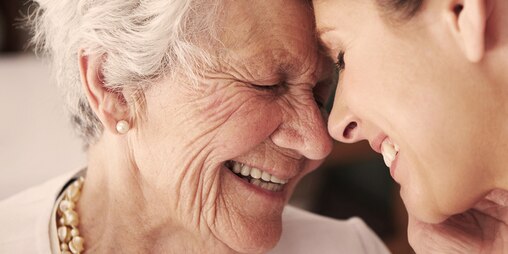 Pani v seniorskom veku a mladšia žena sa smejú – ako demencia ovplyvňuje vašu milovanú osobu.