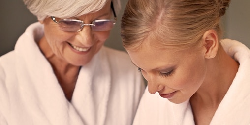 Femme âgée prenant soin de sa peau accompagnée d’une femme plus jeune – Proposer les meilleurs soins d’hygiène à votre proche