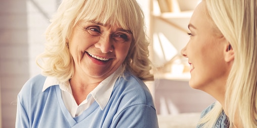 Senhora mais velha a rir com senhora mais jovem – formas de ajudar o seu ente querido a lidar com a incontinência