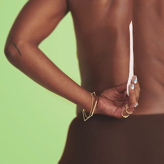 Woman holding a TENA Discreet Ultra Mini Incontinence Liner Thin behind her back