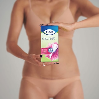 Woman in Underwear showing a package of TENA Discreet Ultra Mini