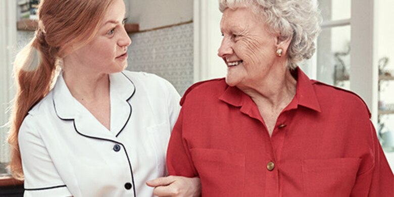 Nurse talking to a smiling elderly woman