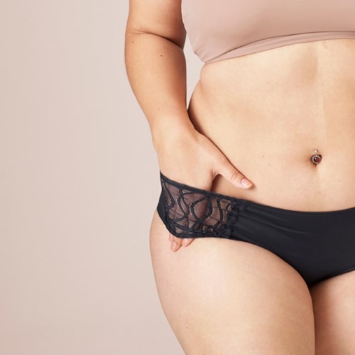 White woman wearing a pair of TENA Silhouette Washable Absorbent Underwear and showing off the stylish lace. 