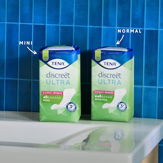 Sachets de protège-slips TENA Discreet Ultra Mini et Normal sur une console.