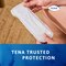 Woman holding the TENA Discreet Ultra pad with the TENA trusted protection