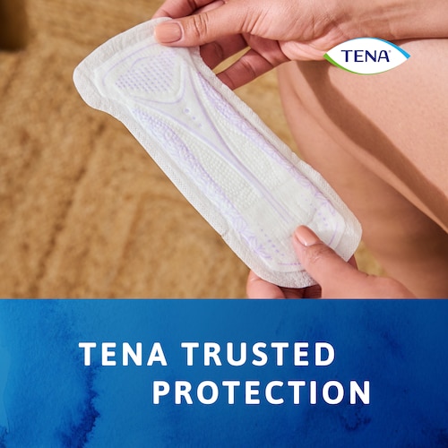 Woman holding the TENA Discreet Ultra pad with the TENA trusted protection