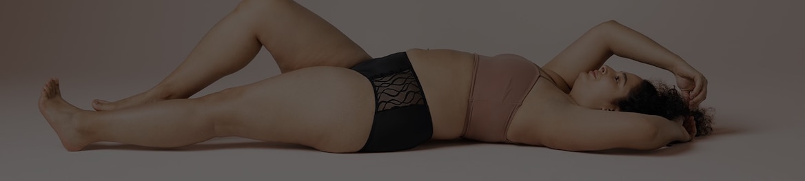 Woman lying down stretching her arm above her head, wearing a pair of TENA Silhouette Washable Absorbent Underwear. 