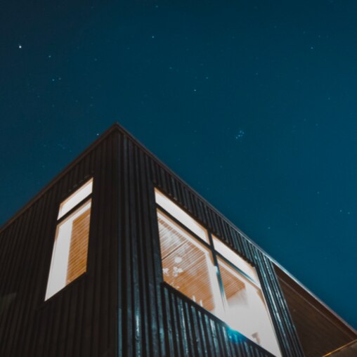 Vue du dessous sur le coin d’une maison avec un ciel étoilé en fond 