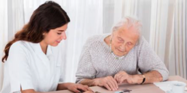 Eine junge und ältere Frau spielen gemeinsam Memory an einem Tisch
