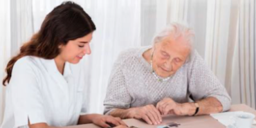 Eine junge und ältere Frau spielen gemeinsam Memory an einem Tisch