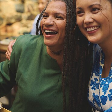 Two smiling persons sitting next to each other