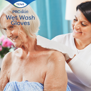 Woman helping older woman getting washed with TENA Wet Wash Gloves