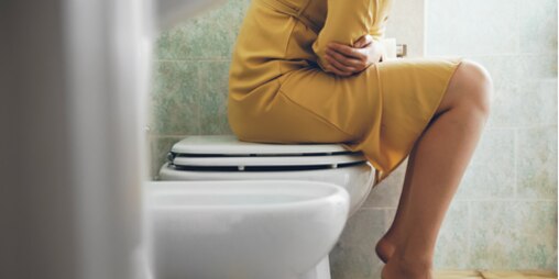 Imagem de uma mulher sentada numa sanita
