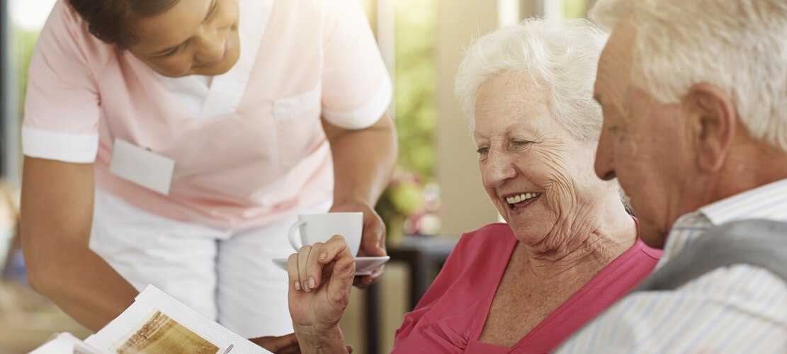 An older woman and an older man laughing together.