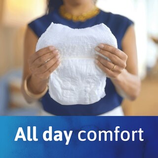 A woman holding a pair of TENA Ultimate Underwear. A text underneath reads "All day comfort".