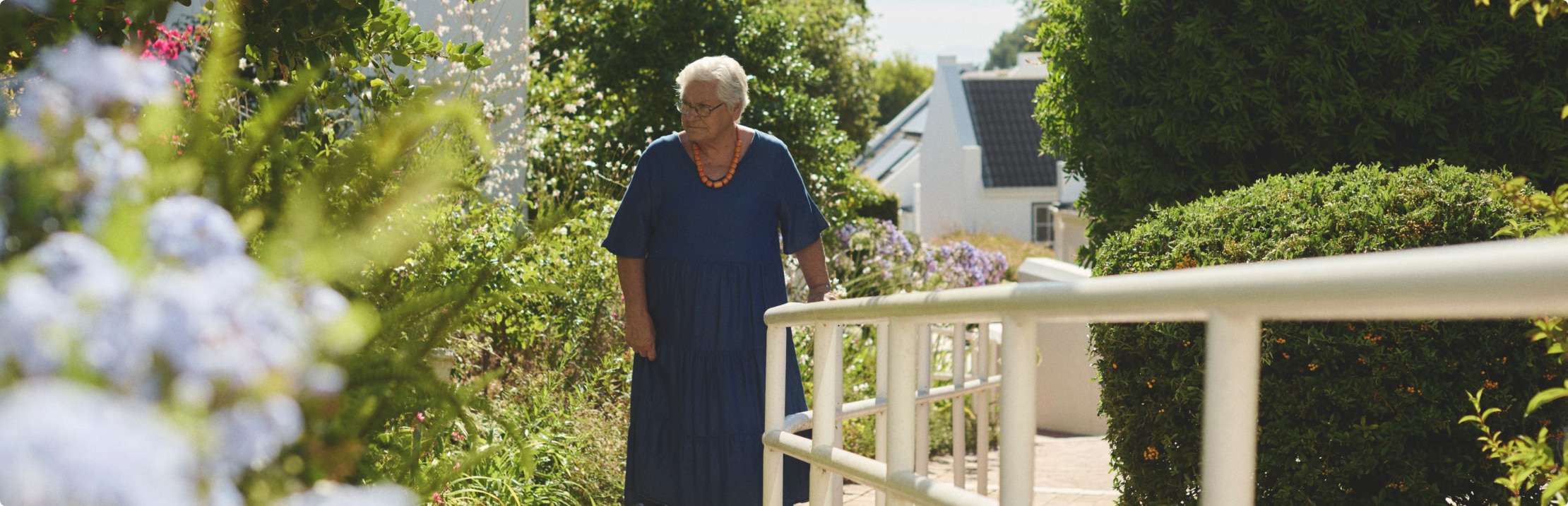 Ein Bewohner eines Pflegeheims geht im Garten spazieren