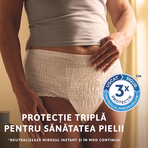 Persoană care stă în picioare, purtând  chilotul TENA. Există o pictogramă cu  protecție triplă pe partea laterală a  imaginii. Mesajul transmite „Protecție triplă pentru sănătatea pielii”