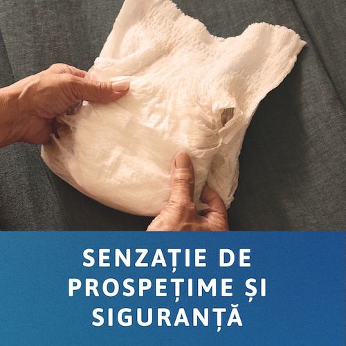 Persoană care ține un chilot TENA pliat  în mâini. Mesajul transmite „Senzație de prospețime şi siguranță”.