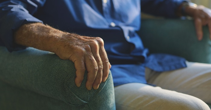 An elderly male nursing home resident sits in an armchair ready to take part in pelvic floor exercises 