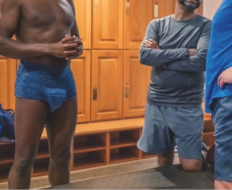 Dva pakiranja proizvoda za inkontinenciju TENA ProSkin prikazana na drvenoj površini. Pakiranje lijevo označeno je ljubičastom bojom kao 'ProSkin Stretch Night', (noćno) dok je ono desno označeno plavom bojom kao 'ProSkin Stretch Day' (dnevno). Oba pakiranja sadrže sliku bijele pelene za odrasle i oznaku razine upijanja 'Super' s više ikona kapljica vode. Scena blago osvijetljene spavaće sobe sa svjetiljkom i biljkom u pozadini.