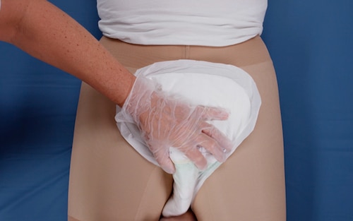 Applicazione di TENA Comfort su una persona sdraiata