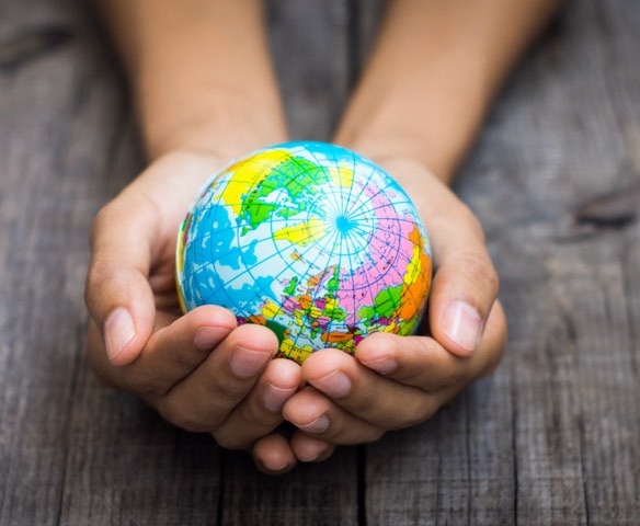 Twee handen die een wereldbol vasthouden.