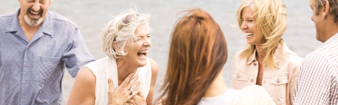 Grupo de mujeres de edad madura al aire libre riendo en actitud amistosa