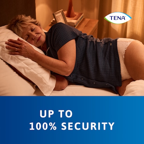 Donna che dorme sul letto indossando TENA Pants Protect+ con elevata protezione - TENA