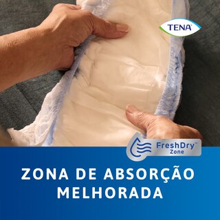 Grande plano do produto TENA Pants protect+ segurado nas mãos a demonstrar a zona de absorção específica