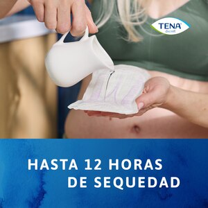 Mujer derramando líquido en una compresa TENA Discreet Ultra para demostrar su capacidad de ofrecer una sensación seca hasta 12 horas