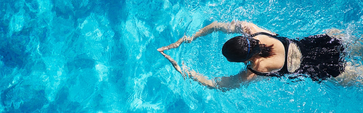 Egy medencében úszó nő