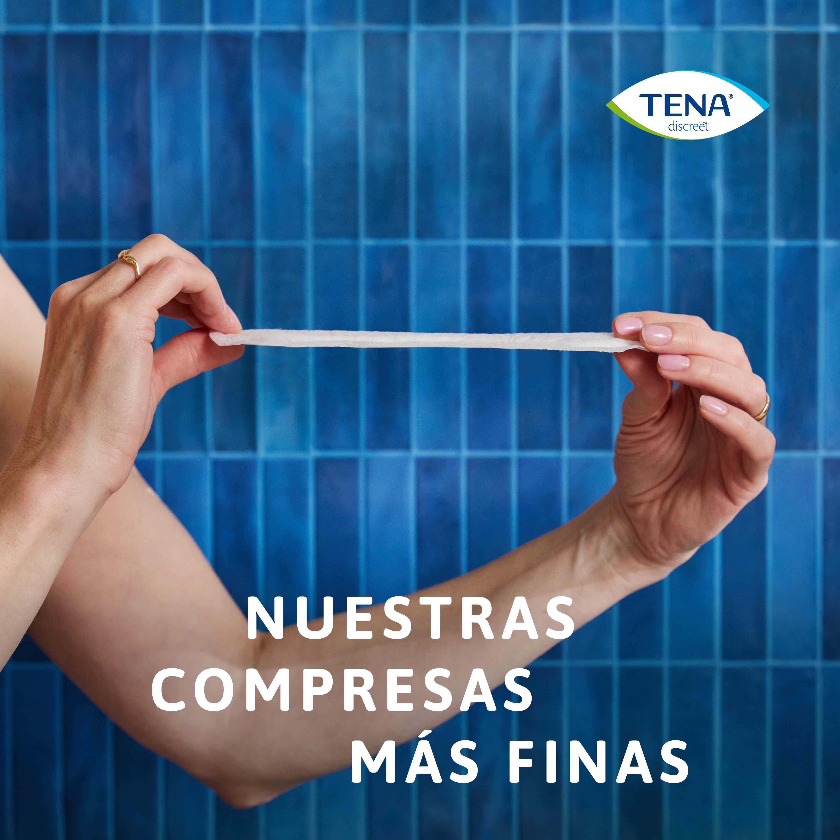 Una mujer sujeta una compresa TENA&nbsp;Discreet Ultra para demostrar lo fina que es, con el texto “nuestras compresas más finas”