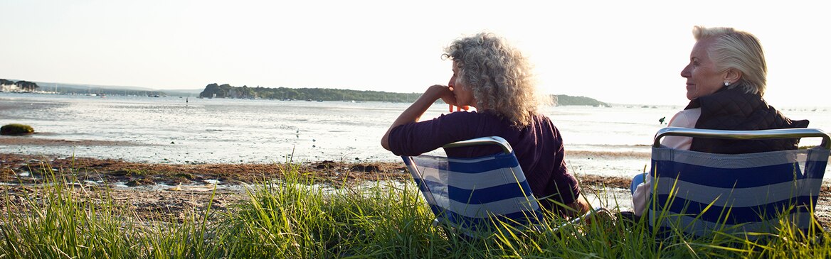 Δύο ηλικιωμένες γυναίκες απολαμβάνουν τη θέα στην παραλία