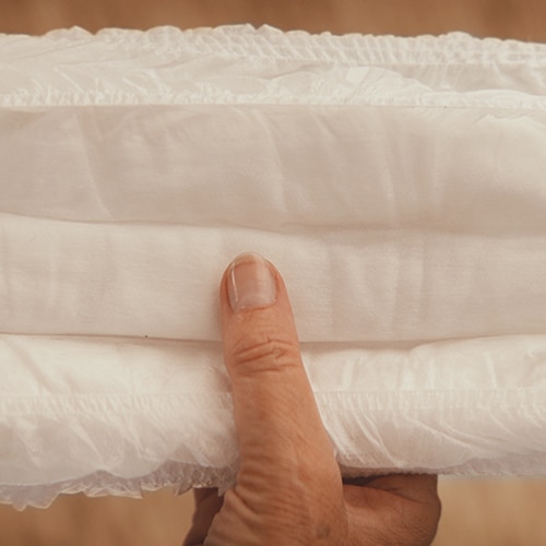 Eine Nahaufnahme einer Hand, die eine Windel berührt