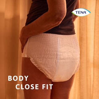 A utilizar o produto TENA Pants protect+ no corpo à noite mostrando o ajuste adaptado ao corpo