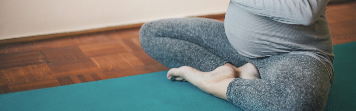Gravid kvinde, der sidder i en yogastilling