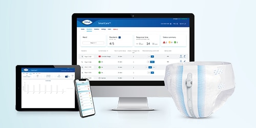 Tablet, smartphone and monitor showing the TENA dashboard, beside a TENA incontinence product with the TENA SmartCare Change Indicator attached