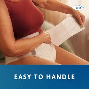 En kvinde tilpasser TENA Proskin Stretch bukseble