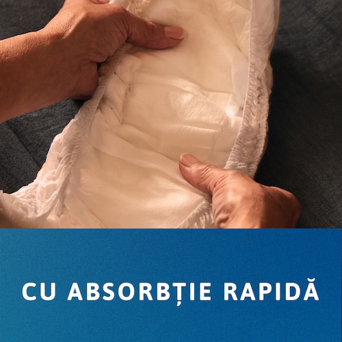 Persoană care ține un chilot TENA cu  ambele mâini. Mesajul transmite „absorbție rapidă”