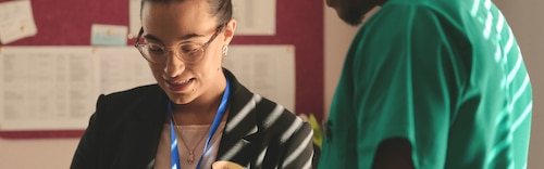 Two healthcare professionals looking down at an iPad.