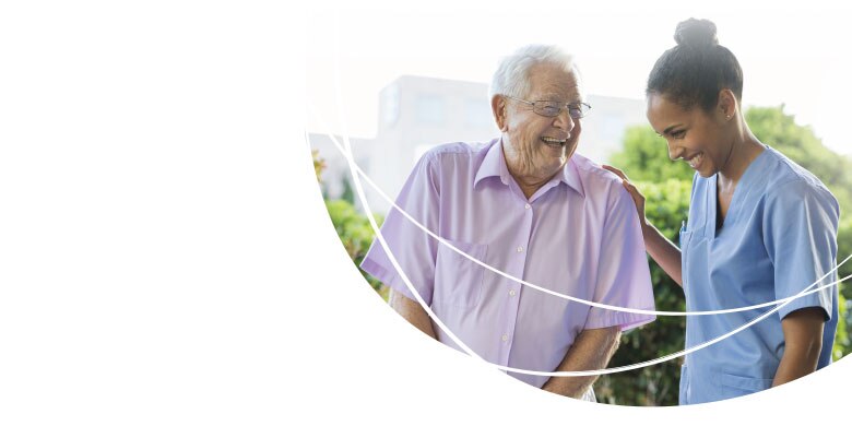 Image of Caregiver and Resident Walking in Garden - TENA Professional