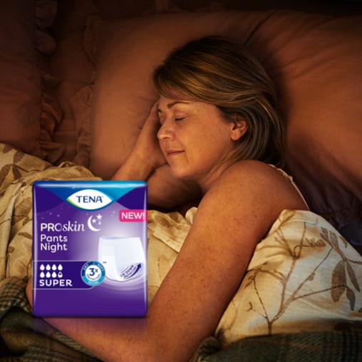 Una donna anziana dorme profondamente nel suo letto. In primo piano c’è una confezione di TENA ProSkin Pants Night. 